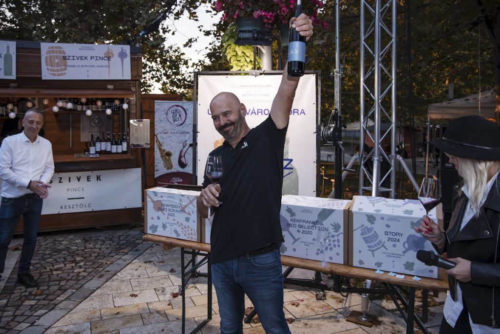 Gergő Káldi holding the “Story” 2022 Cabernet Franc–Merlot bottle at the Újpest City Wine 2026 award ceremony.